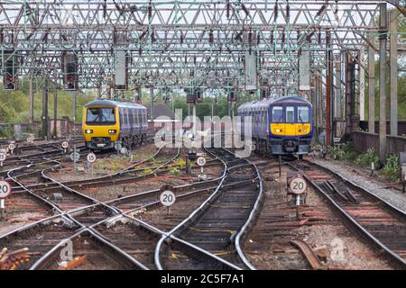 Nordzüge, die in der Manchester Piccadilly Station durch die Kehle der Klasse 319 319368 und der Klasse 323 323230 fahren Stockfoto