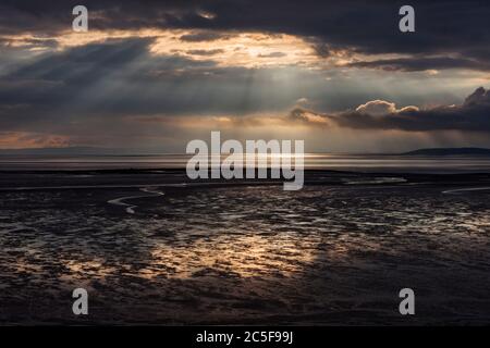 Vom schwarzen Himmel fallen Lichtwellen über den Strand der Morecambe Bucht bei Bolton Le Sands Stockfoto