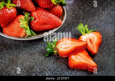 Fresh dessert strawberries in plate on gray background. Close up. Stockfoto