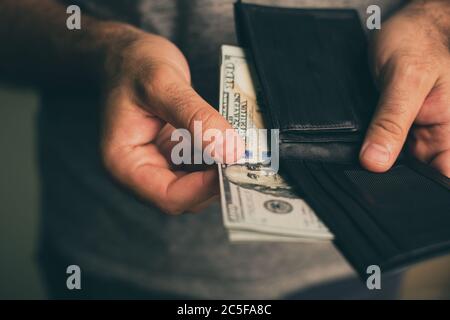 Mann schaut in die Brieftasche. Bargeld. Wohlhabender Mann, der sein Geld zählt. Nahaufnahme. Stockfoto