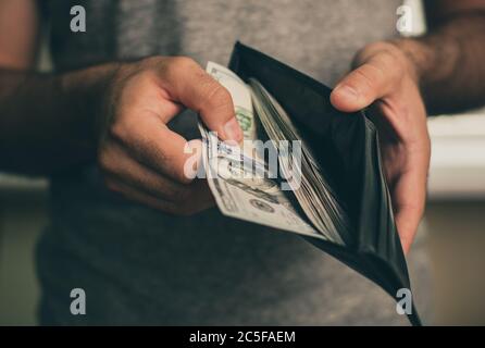 Mann schaut in die Brieftasche. Bargeld. Wohlhabender Mann, der sein Geld zählt. Nahaufnahme. Stockfoto