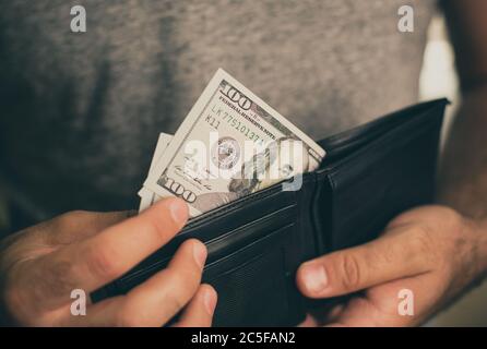 Mann schaut in die Brieftasche. Bargeld. Wohlhabender Mann, der sein Geld zählt. Nahaufnahme. Stockfoto