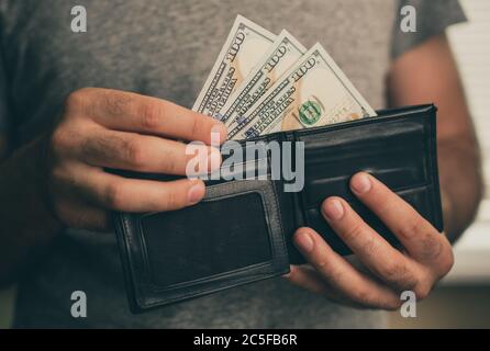 Mann schaut in die Brieftasche. Bargeld. Wohlhabender Mann, der sein Geld zählt. Nahaufnahme. Stockfoto