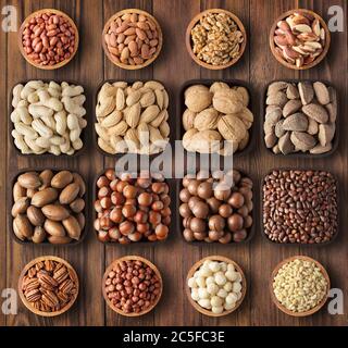 Geschälte und geschälte Nüsse auf Hintergrund Holztisch. Zusammensetzung Gesundheit Lebensmittel: Pekannüsse, Haselnüsse, Walnüsse, Mandeln, Macadamia, Erdnüsse, Kiefer, brasilianisch Stockfoto