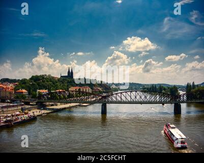 Luftaufnahme der Kirche Vysehrad in Prag an einem heißen Sommertag mit Booten und Menschen genießen Moldau Ufer Stockfoto