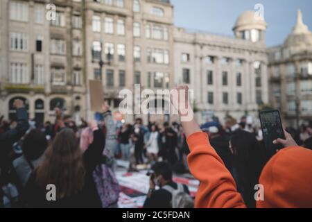 Porto, Portugal - 6. Juni 2020: Die Demonstration gegen Rassendiskriminierung Black Lives Matter; selektiver Fokus auf eine aufgeworfene Faust eines Mannes Stockfoto