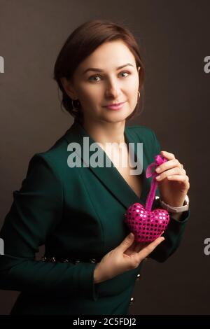 Frau Brunet Studio Porträt. Holding Spielzeug in Form eines Herzens. Konzept des Valentinstag Liebe Urlaub. Stockfoto
