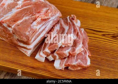 Stücke von rohem frischem Schweinefleisch Steak mit auf einem Holzbrett Stockfoto