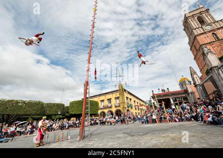 Die berühmten Voladores de Papantla, die Papantla Flyers, führen ihre alte mesoamerikanische Zeremonie im Jardin Allende während der einwöchigen Fiesta des Schutzheiligen Michael in San Miguel de Allende, Mexiko, durch. Stockfoto