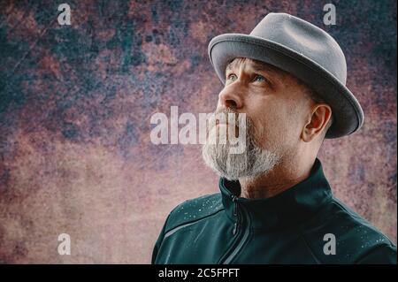 Älterer Mann mit grauem Bart, der eine Fedora trägt Stockfoto