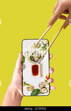 Bestellen Sie Sushi-Set mit Handy-App. Online-Konzept für die Lebensmittelzustellung. Stockfoto