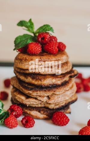 Schokoladen-Pfannkuchen mit frischen Himbeeren und Minze auf schwarzem Hintergrund Stockfoto
