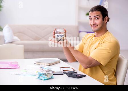 Junger Mann im Konzept der Budgetplanung Stockfoto