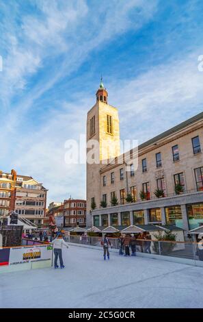 Menschen Eislaufen auf dem Wintermarkt und Hauptplatz der Stadt mit dem ehemaligen Kultur-und Partypalast im Hintergrund, Oostende, Belgien. Stockfoto