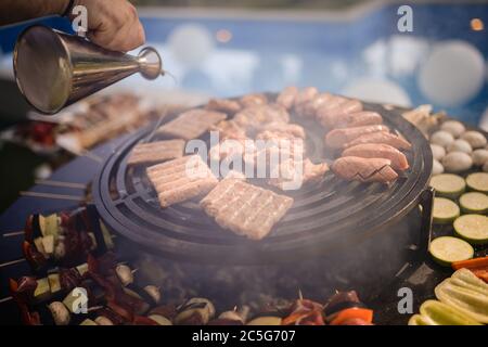 Der Koch grillt Fleisch und Gemüse im Hinterhof Stockfoto