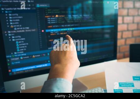 Mann Hände zeigen Codierung HTML und Programmierung entwickeln auf dem Bildschirm Computer. Stockfoto