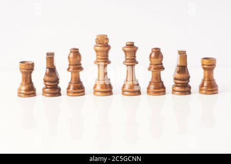 Schachfiguren aus Holz isoliert gegen Weiß Stockfoto