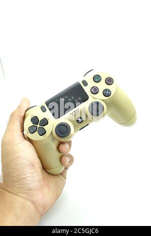 Ein goldener PlayStation 4 DS4-Controller vor isoliertem weißem Hintergrund Stockfoto