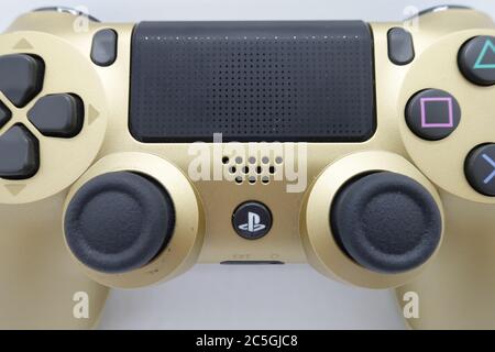 Ein goldener PlayStation 4 DS4-Controller vor isoliertem weißem Hintergrund Stockfoto