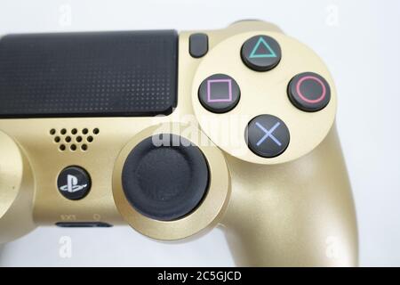 Ein goldener PlayStation 4 DS4-Controller vor isoliertem weißem Hintergrund Stockfoto