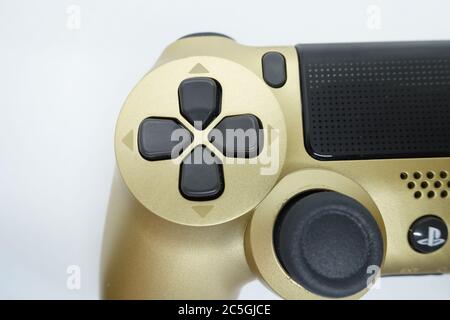 Ein goldener PlayStation 4 DS4-Controller vor isoliertem weißem Hintergrund Stockfoto