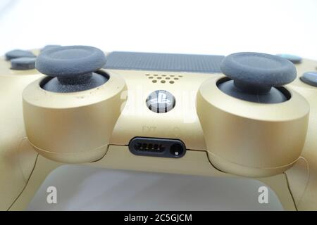 Ein goldener PlayStation 4 DS4-Controller vor isoliertem weißem Hintergrund Stockfoto