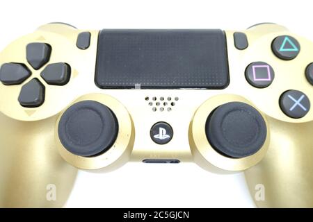 Ein goldener PlayStation 4 DS4-Controller vor isoliertem weißem Hintergrund Stockfoto