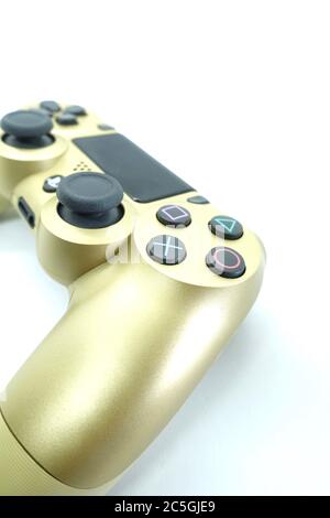 Ein goldener PlayStation 4 DS4-Controller vor isoliertem weißem Hintergrund Stockfoto