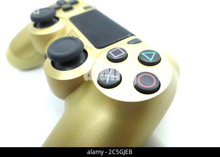 Ein goldener PlayStation 4 DS4-Controller vor isoliertem weißem Hintergrund Stockfoto