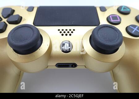 Ein goldener PlayStation 4 DS4-Controller vor isoliertem weißem Hintergrund Stockfoto