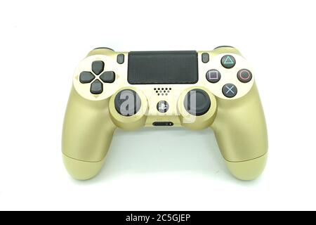 Ein goldener PlayStation 4 DS4-Controller vor isoliertem weißem Hintergrund Stockfoto