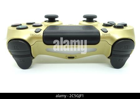 Ein goldener PlayStation 4 DS4-Controller vor isoliertem weißem Hintergrund Stockfoto