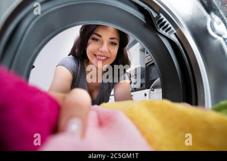 Frau, Die Waschmaschinen Oder Einen Tuchtrockner Verwendet Stockfoto