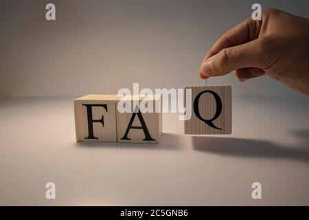 FAQ Wort aus Holzwürfeln. Spot hell und weißer Hintergrund. Nahaufnahme. Stockfoto