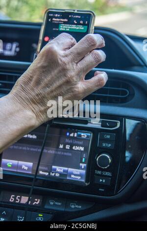 Eine Frau, die ihr Handy während der Fahrt benutzt. Stockfoto