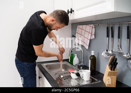 Reinigen Von Verstopften Abflussverstopfungen Im Küchenwaschbecken Mit Stößel Stockfoto