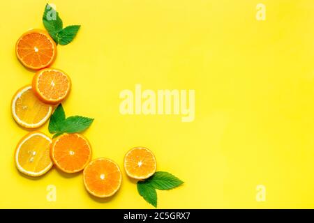Orangefarbene Scheiben mit Blättern in gelber Draufsicht Stockfoto