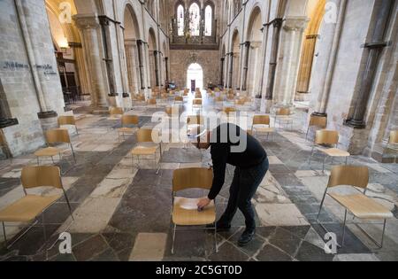 Senior Verger Luke Marshall reinigt gesellschaftlich distanzierte Stühle in der Chichester Cathedral in West Sussex, während sie sich darauf vorbereiten, am 5. Juli für den öffentlichen Gottesdienst wieder zu öffnen, da weitere Beschränkungen für die Sperrung von Coronaviren in England aufgehoben werden. Stockfoto
