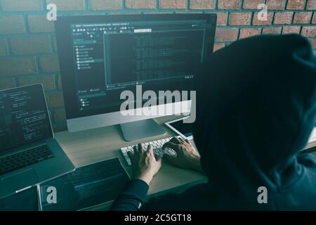 Hacker in der Haube arbeiten mit Computer mit Hacking brechen in Datenserver. Stockfoto