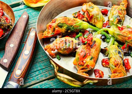 Köstliche gebratene Zucchini Blumen gefüllt mit sonnengetrockneten Tomaten.Sommer Essen. Stockfoto