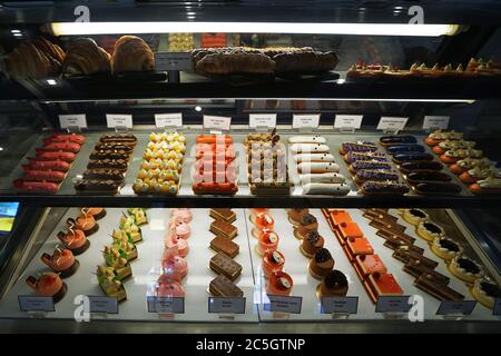 Verschiedene Geschmack bunte eclair und Französisch Gebäck Bäckerei in Glas Vitrine Box angezeigt Stockfoto