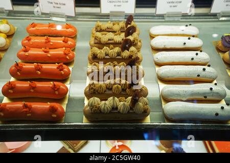 Verschiedene Geschmack bunte eclair und Französisch Gebäck Bäckerei in Glas Vitrine Box angezeigt Stockfoto