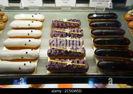 Verschiedene Geschmack bunte eclair und Französisch Gebäck Bäckerei in Glas Vitrine Box angezeigt Stockfoto