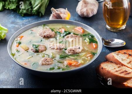 Italienische Hochzeitssuppe mit Fleischbällchen, Pasta-Orzo und Gemüse. Serviert auf dem Teller Stockfoto