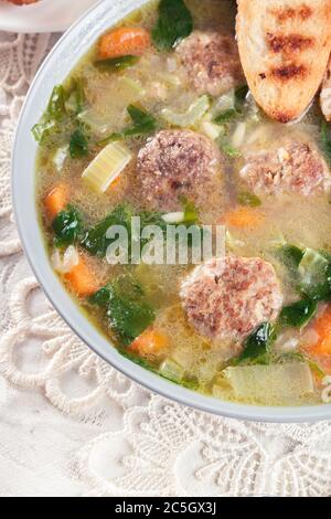 Italienische Hochzeitssuppe mit Fleischbällchen, Pasta-Orzo und Gemüse. Serviert auf dem Teller Stockfoto