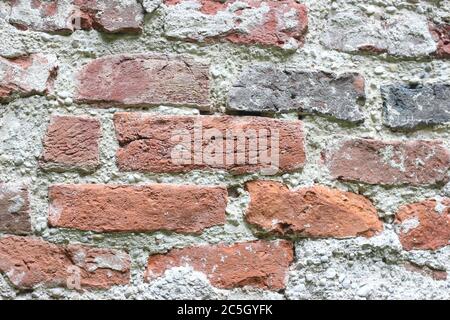 Stück Ziegelwand, rauer Hintergrund, rauer Putz. Stockfoto