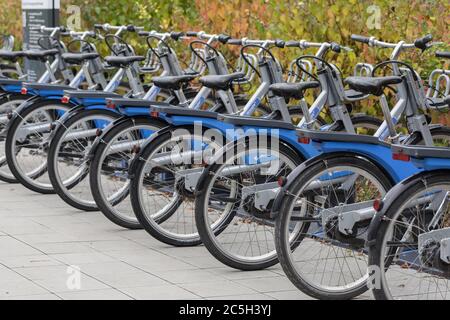 Blick auf Fahrräder in einer Reihe an einer Verleihstation. Stockfoto