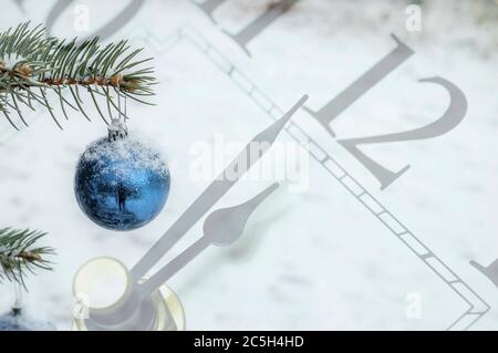 Silvester Dekoration: Blaue Fleischbäckeauf einem Weihnachtsbaum, mit einer Minute bis Mitternacht Uhr Hintergrund. Stockfoto