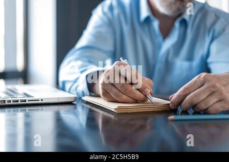 Geschäftsmann, der in einem Restaurant im Business Center sitzt und Dokumente durchschaut. Stockfoto