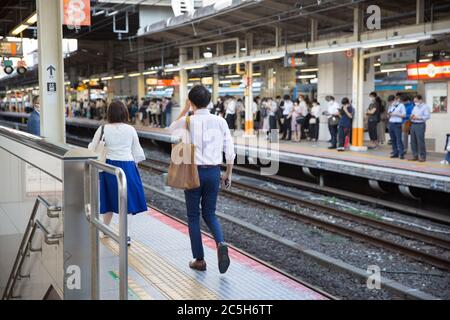 Tokio, Japan. Juli 2020. Pendler auf einem Bahnsteig warten auf einen Zug am Bahnhof Yokohama.die japanische Regierung hat den Bewohnern geraten, überfüllte Plätze am Abend aufgrund der steigenden Zahl von Coronavirus Covid-19 Infektionen nach der Wiedereröffnung der Wirtschaft zu vermeiden. Kredit: SOPA Images Limited/Alamy Live Nachrichten Stockfoto